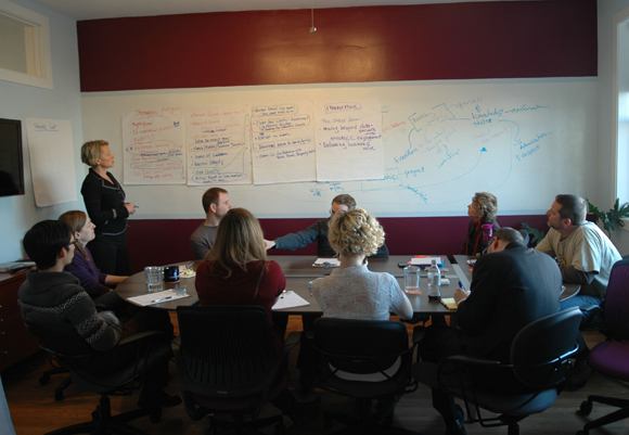 A creative brainstorming session with whiteboard, facilitator, and participants