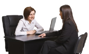 photo of two women sitting at a table with computers performing a ux interview
