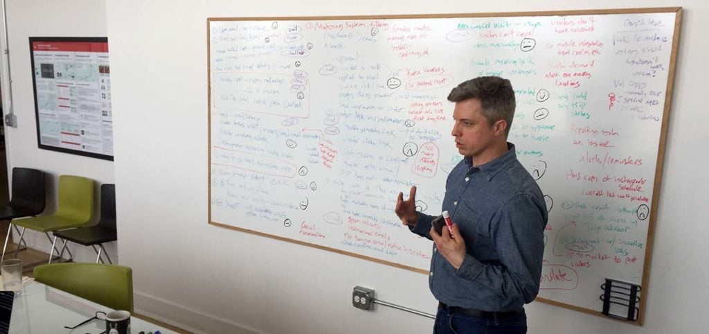 Facilitator exploring journey map steps in a workshop setting.