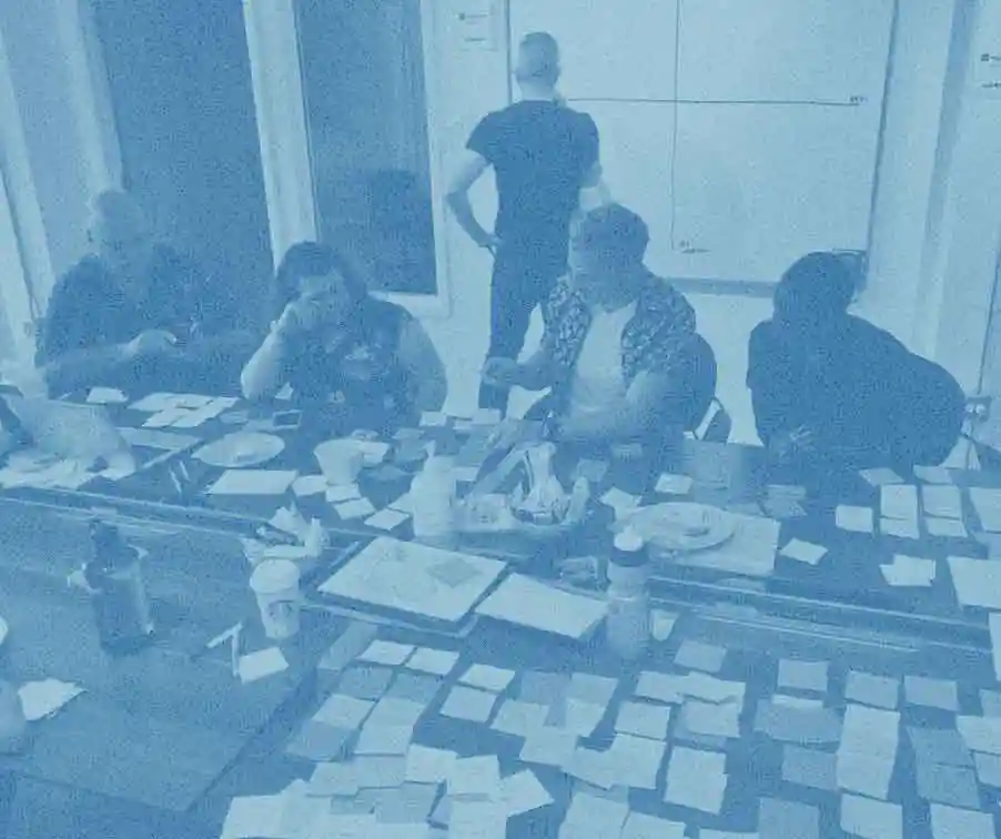 Treated photo of people working around a table filled with sticky notes