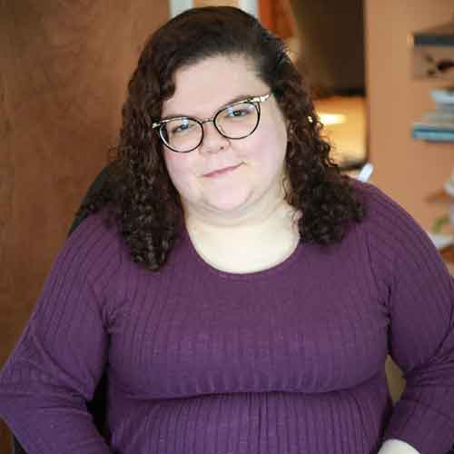 Photo of Emily Ladau who is wearing glasses and a burgundy sweater