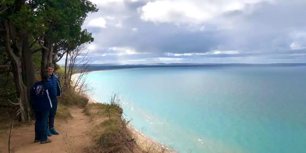 Two people standing atop a dune overlooking Lake Michigan in Sleeping Bear Dunes National Lakeshore.